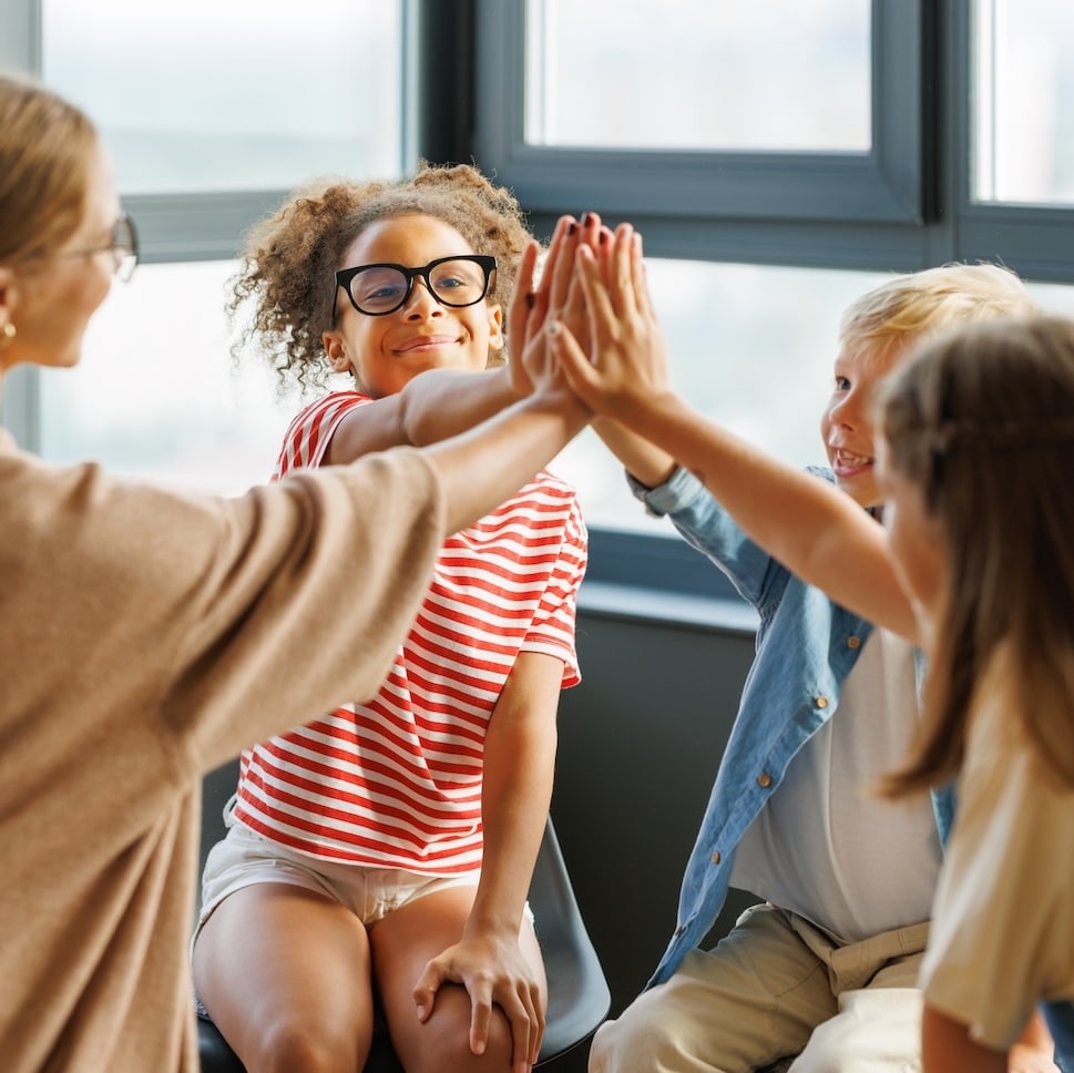School psychologist with a group of children conducts a mental health lesson and successful completion of collective school work